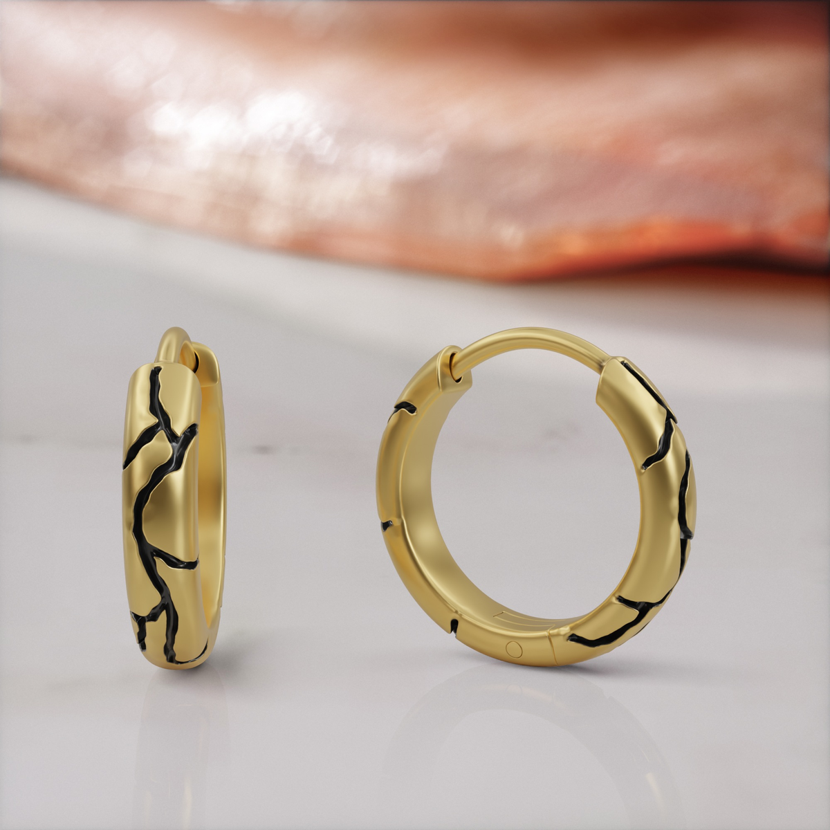 Kintsugi huggie earrings in yellow gold, the pair, black enamel seams across the band