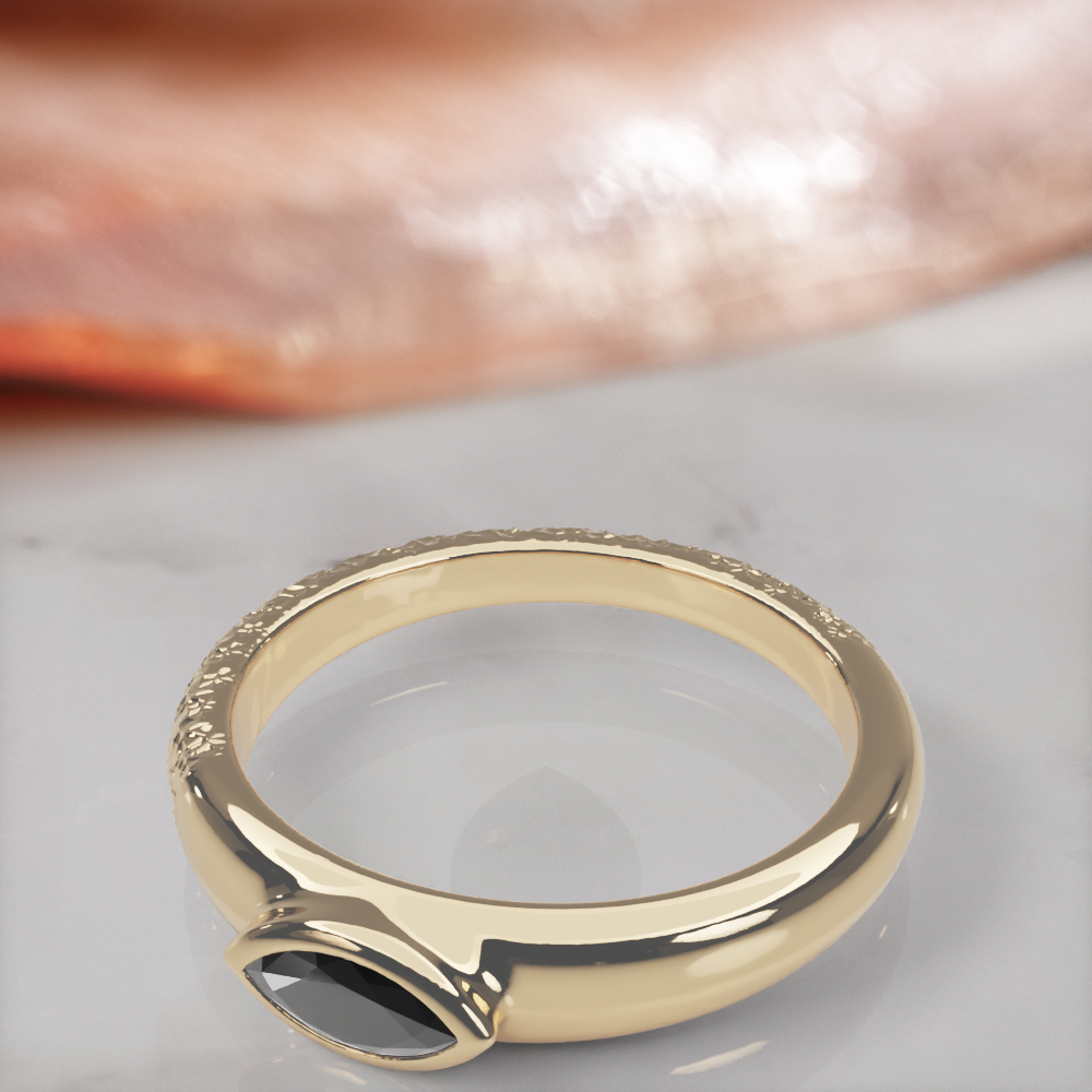 Disturbed engagement ring in yellow gold, close-up of the bezel-set marquise black diamond and the hammered texture
